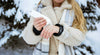 Woman applying cream or lotion from a tube outside in a winter scene