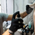 Tattoo artist spraying Calendula onto customers skin