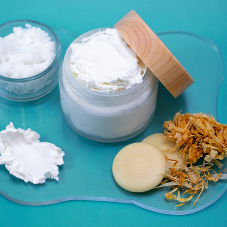 Jar of white cream with a wooden lid on a blue background