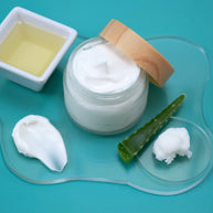 Jar of white cream with a wooden lid on a blue background