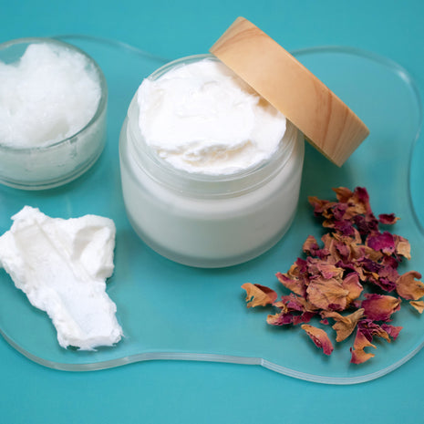 Jar of white cream with a wooden lid on a blue background