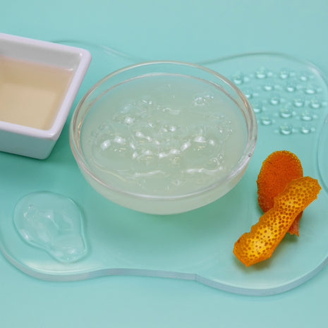 Clear gel-like substance in a glass bowl on a light blue background