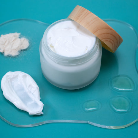 Jar of Silk Lotion with a wooden lid on a teal background