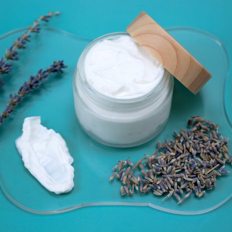 Jar of Lavender Lotion with lavender flowers on a blue background