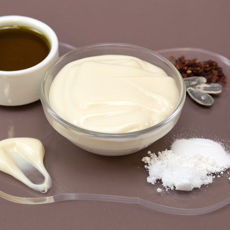 Bowl of Antioxidant Facial Serum with ingredients on a brown surface