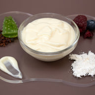 Glass bowl of Vitamin C Facial Serum with berries and aloe vera on a brown background