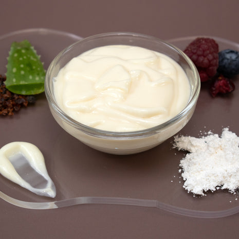 Glass bowl of Vitamin C Facial Serum with berries and aloe vera on a brown background