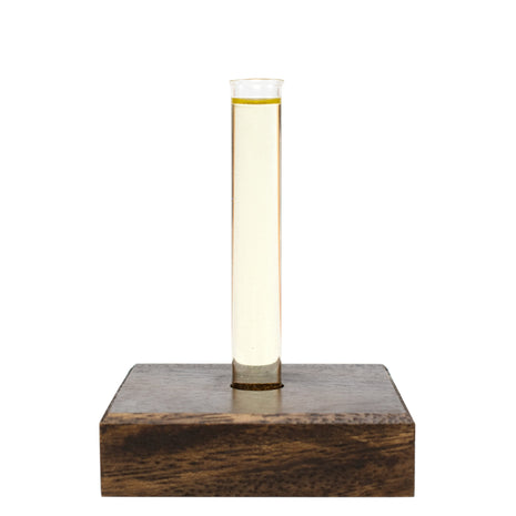 Glass tube with Sensitive Skin Massage & Body Oil on a wooden base on a white background