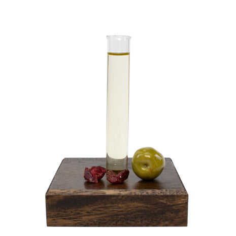 Test tube with Shaving Oil on a wooden block with fruits on a white background