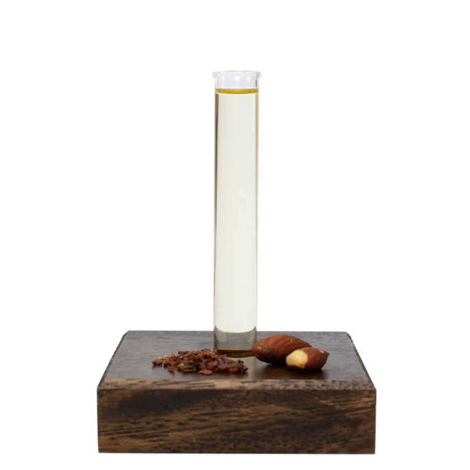 Glass beaker of Massage Oil with a wooden base on a white background