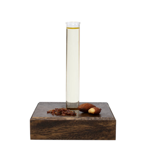 Glass beaker of Massage Oil with a wooden base on a white background