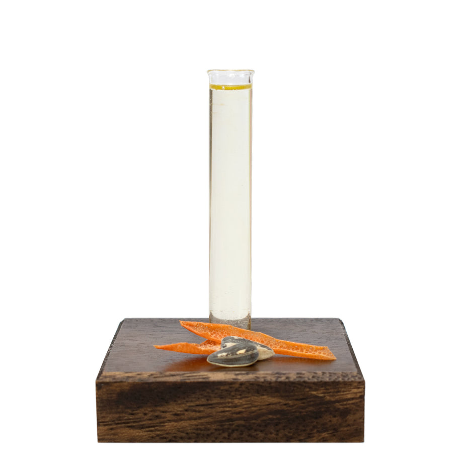 Essential Tune Up Blend in a glass beaker on a wooden base with natural ingredients