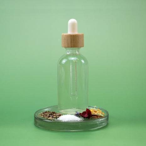 Clear glass dropper bottle with wooden cap with Chaotic Facial Toner and natural ingredients on a green background