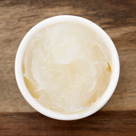 White container with Castor Jelly on a wooden surface