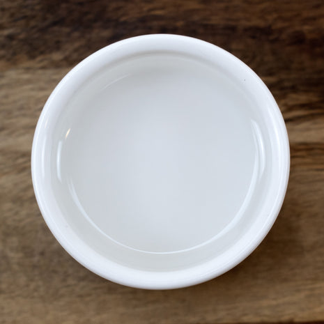 White ceramic bowl with Lactic Acid 88% on a wooden surface