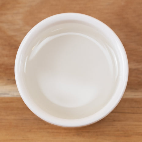 White container with MCT Oil (Medium Chain Triglycerides) on a wooden surface