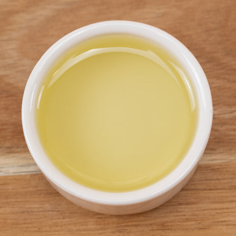 Grapeseed Oil in a white container on a wooden surface