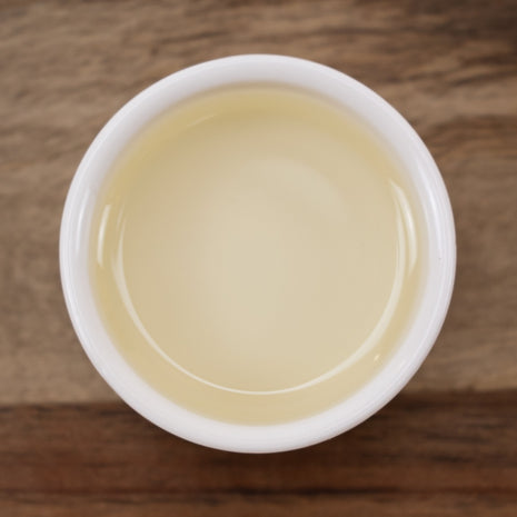 White cup filled with a Daikon Seed Extract on a wooden surface