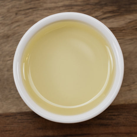 White container with Camellia Seed Oil (Responsibly Grown) on a wooden surface
