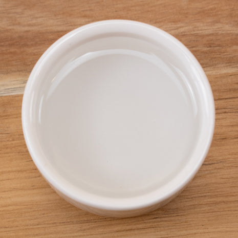 White ceramic bowl with Pentylene Glycol Natural on a wooden surface