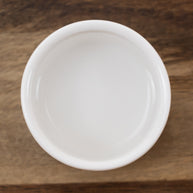 White ceramic bowl with Cucumber Distillate on a wooden surface