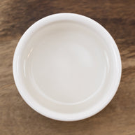 White ceramic bowl with Witch Hazel Distillate (14% Alcohol) on a wooden surface