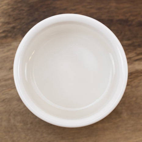 White ceramic bowl with Witch Hazel Distillate (14% Alcohol) on a wooden surface