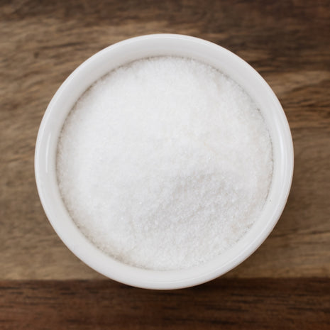 White bowl filled with Vitamin C (Ascorbic Acid) on a wooden surface