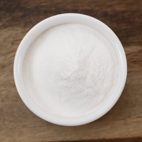 White container of Xanthan Gum on a wooden surface