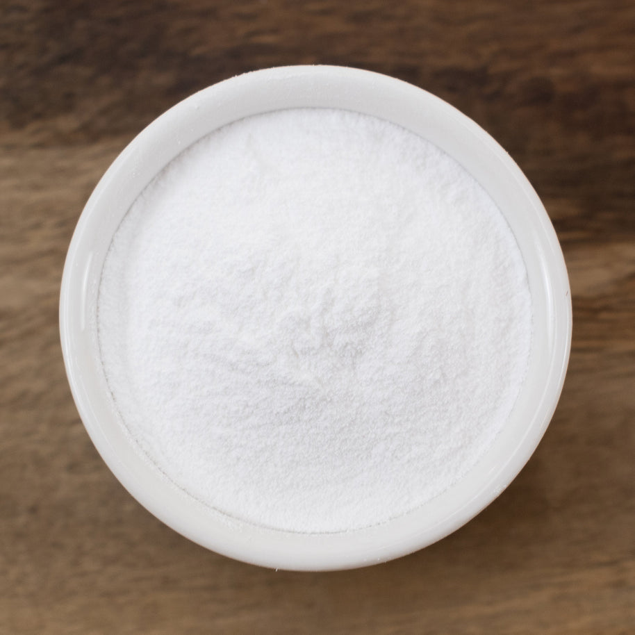 Hyaluronic Acid Powder in a round container on a wooden surface