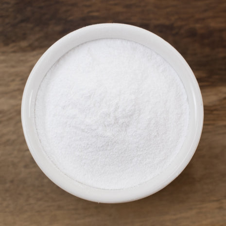 Hyaluronic Acid Powder in a round container on a wooden surface