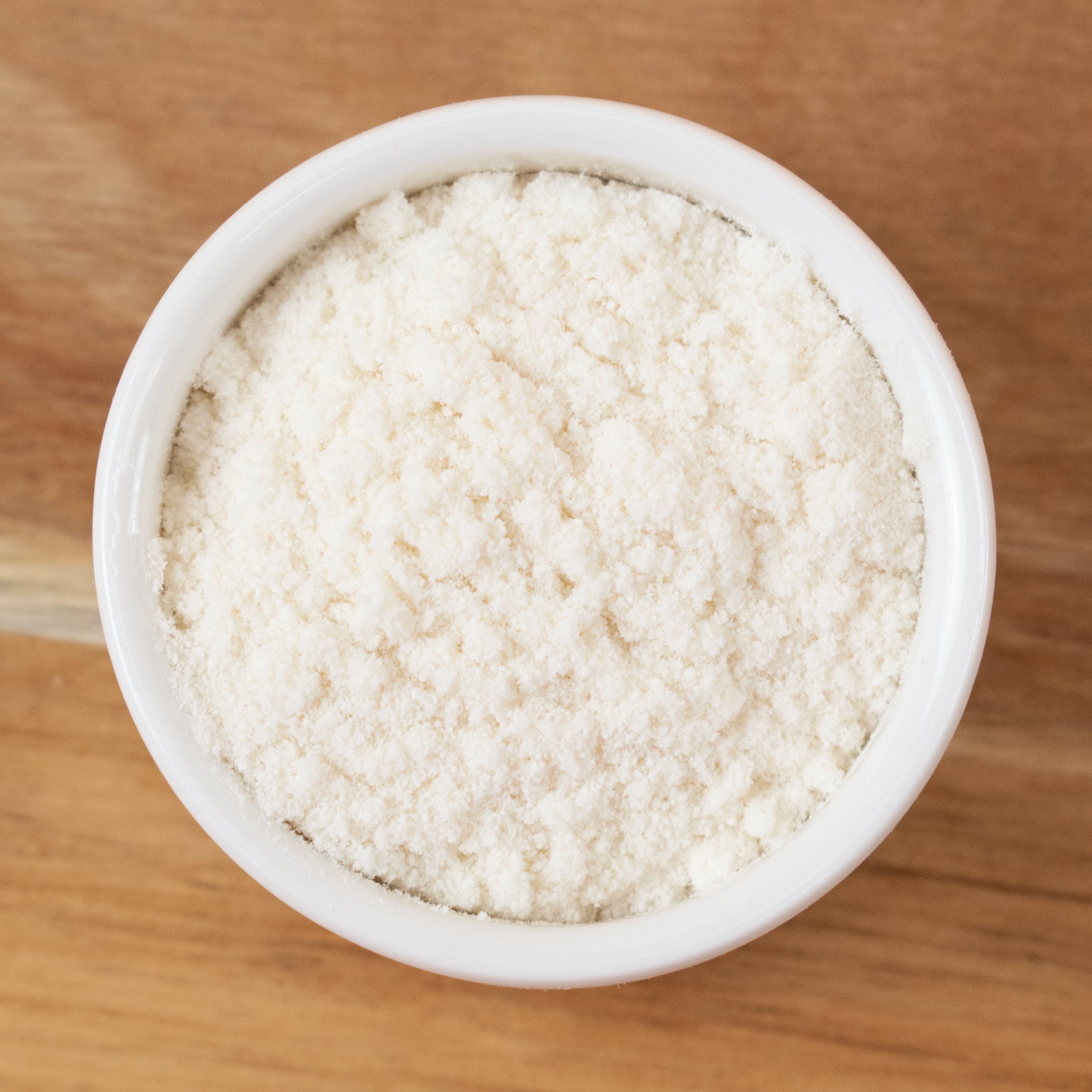 Hydroxyethylcellulose in a white bowl on a wooden surface